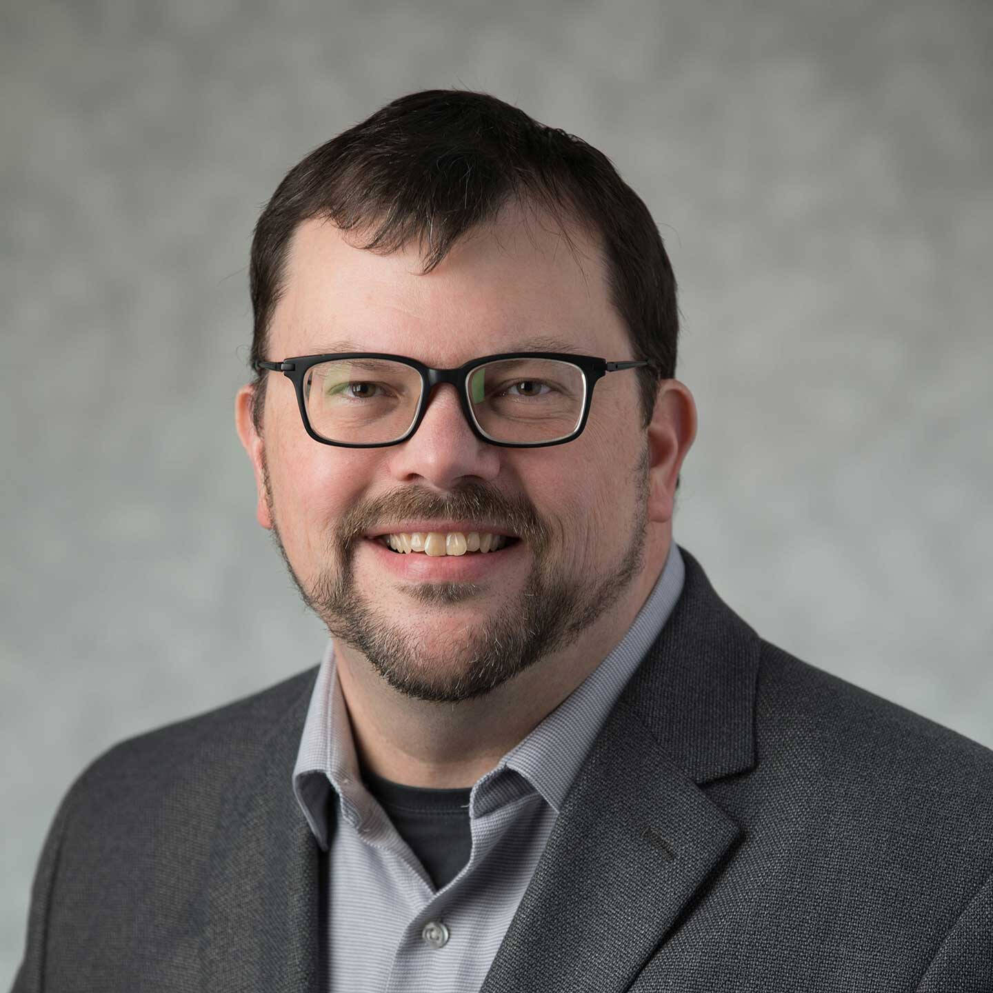 Dr. Haven wearing a grey suit jacket and a light grey shirt